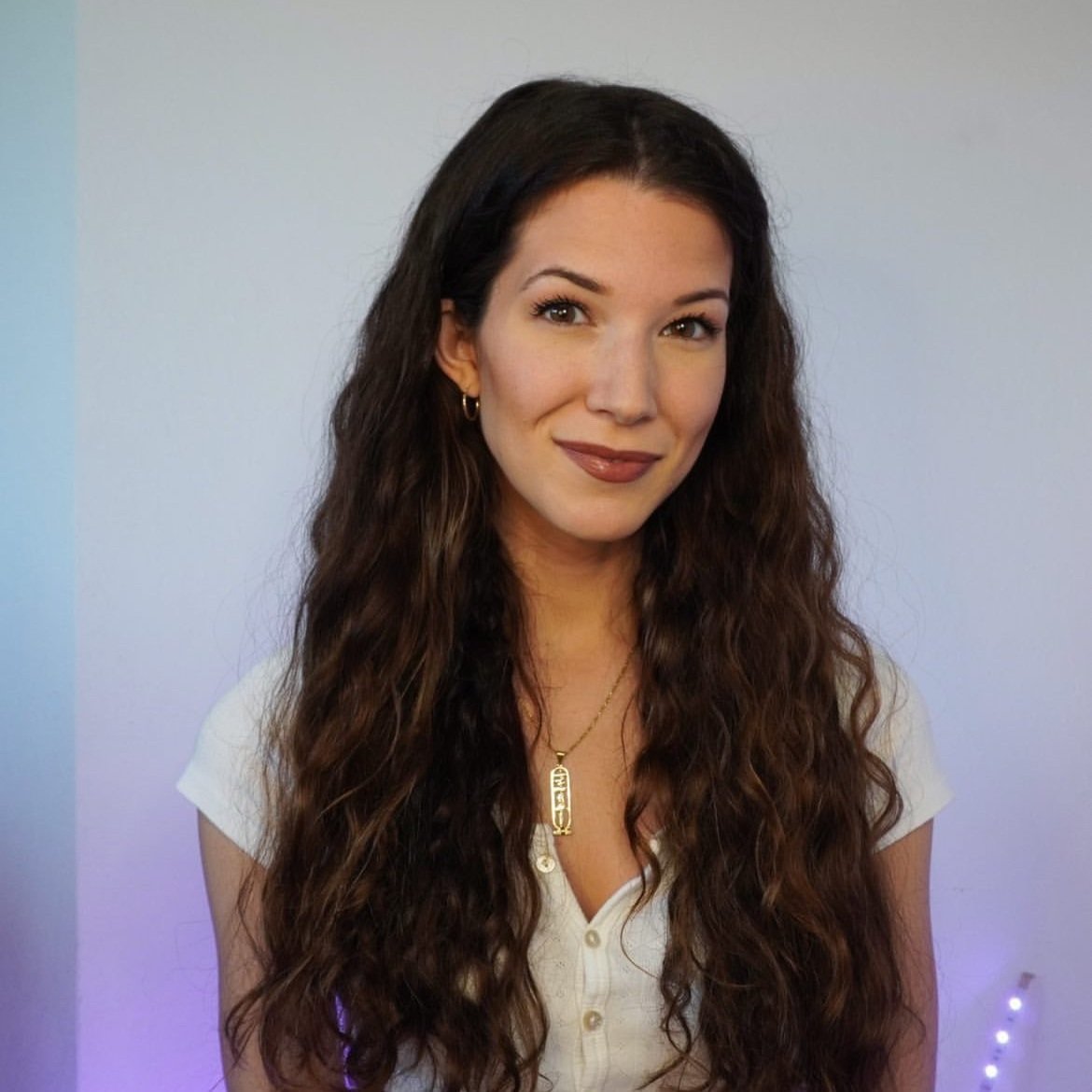 Nicole B Cameron with long flowing hair in a white top and ombre background