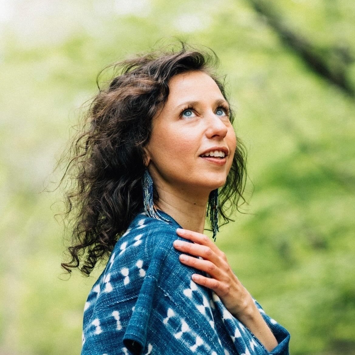 Melinda DiOrio gazing at the sky in front of trees