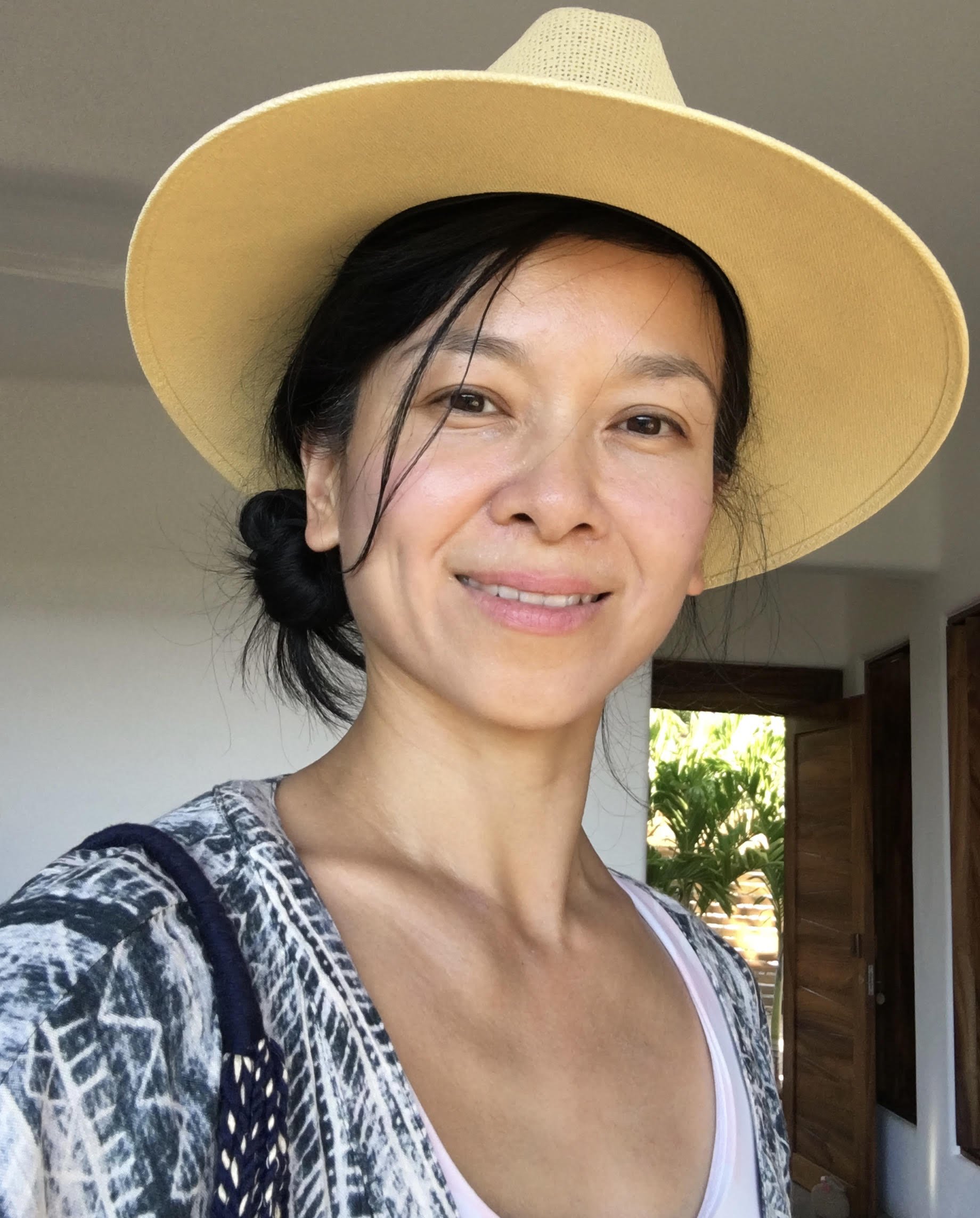 Pam Jones in a wide brim hat standing in front of a doorway