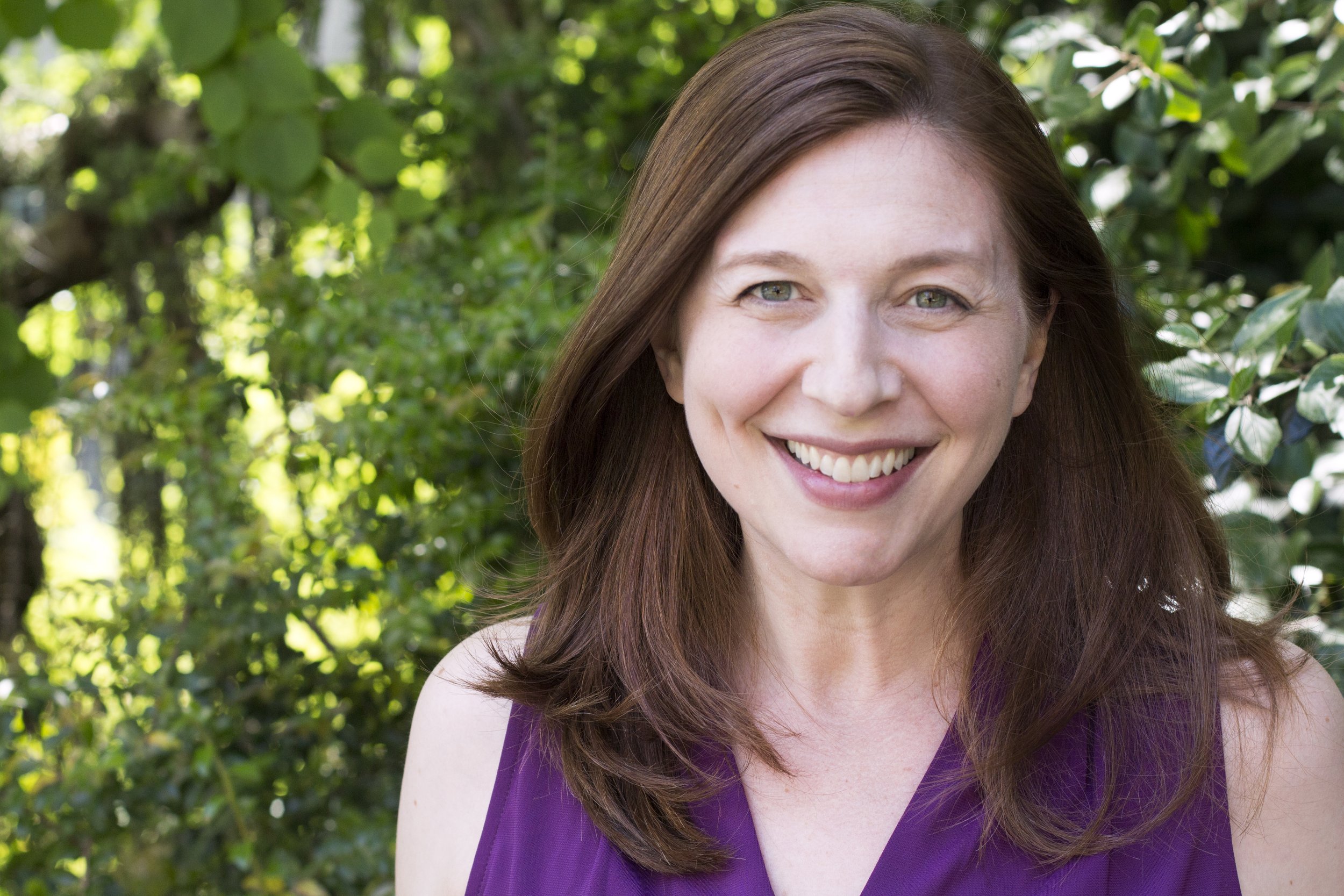 Rachel Goldsmith Turow standing in a purple shirt in front of trees