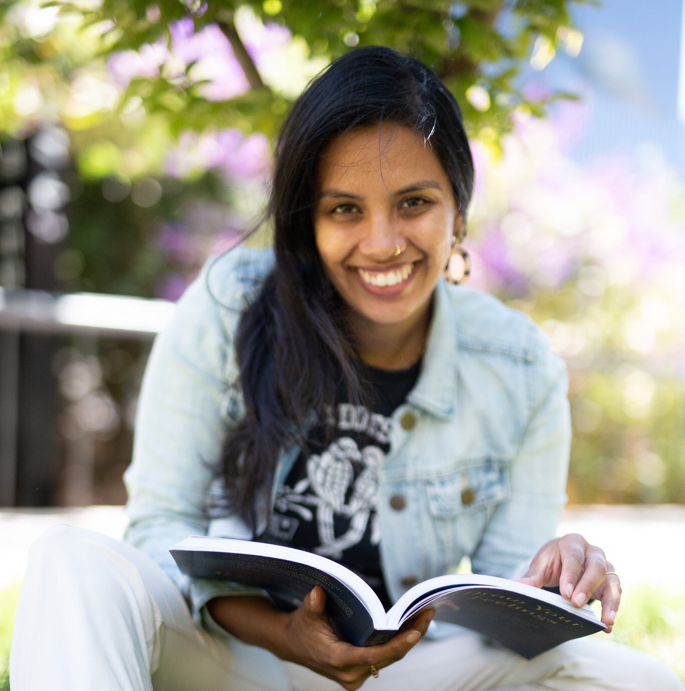 Rukmini Poddar in a denim jacket holding her book