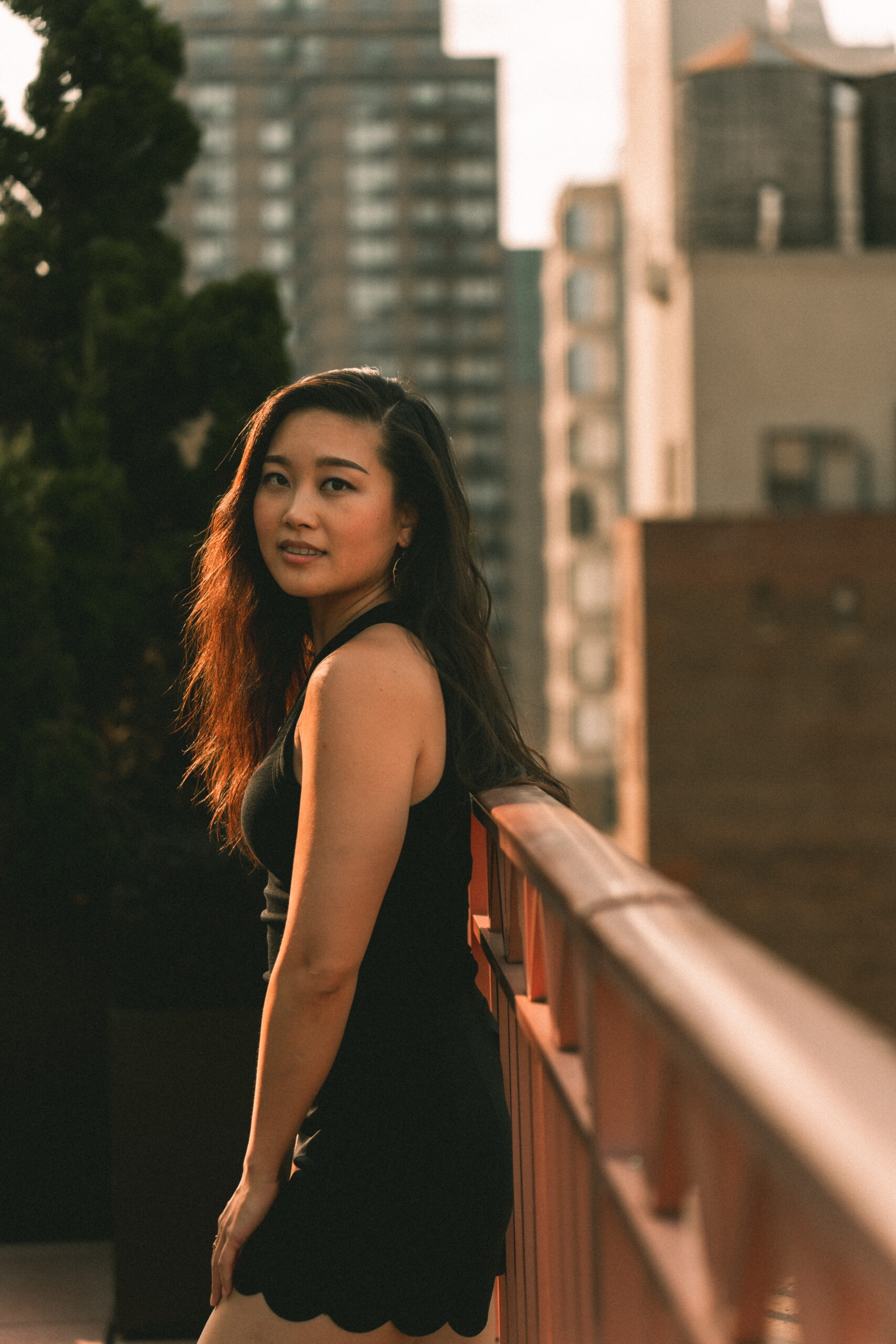 jessica hwang standing on a new york city rooftop with buildings in the background