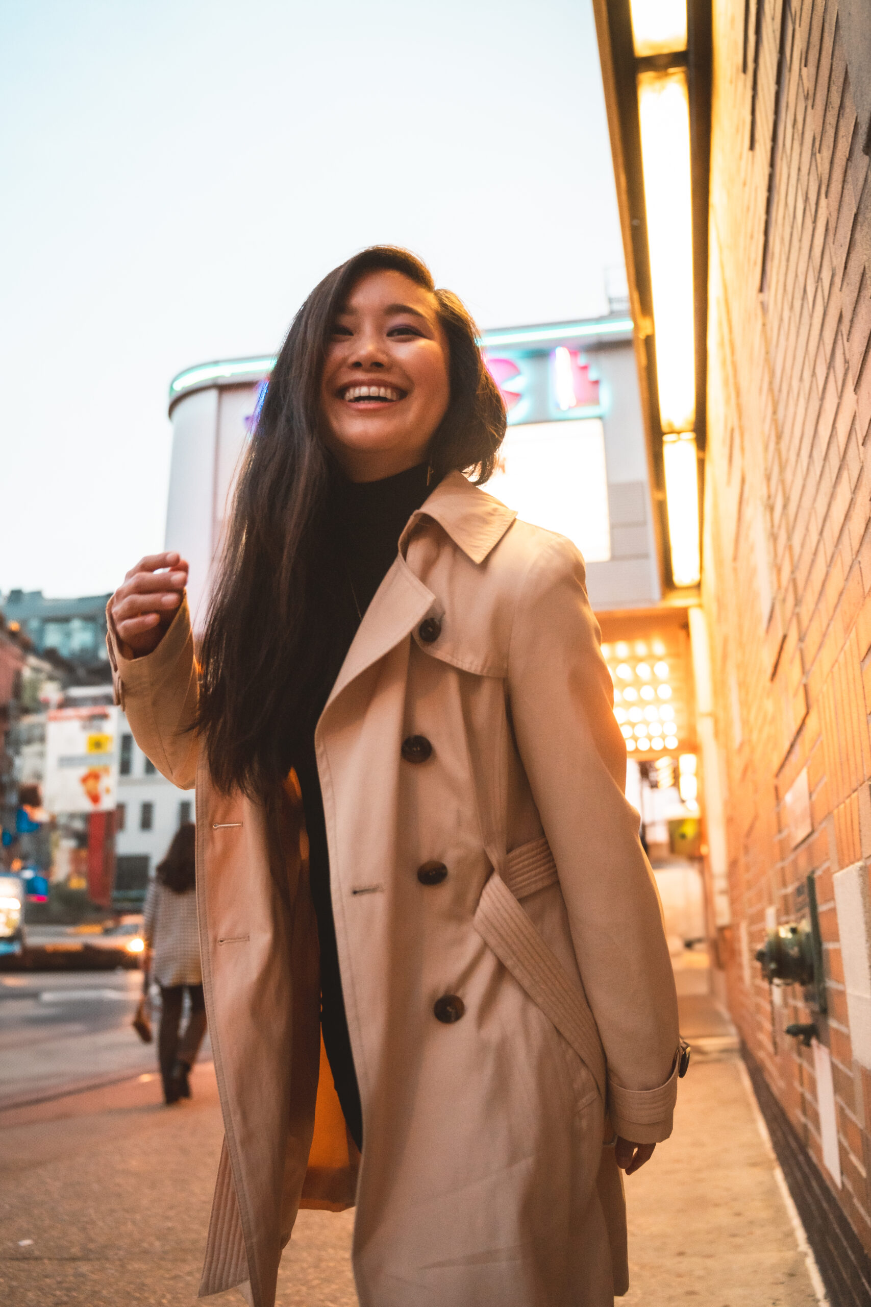 Jessica Hwang in a tan colored jacket smiling on the street of manhattan